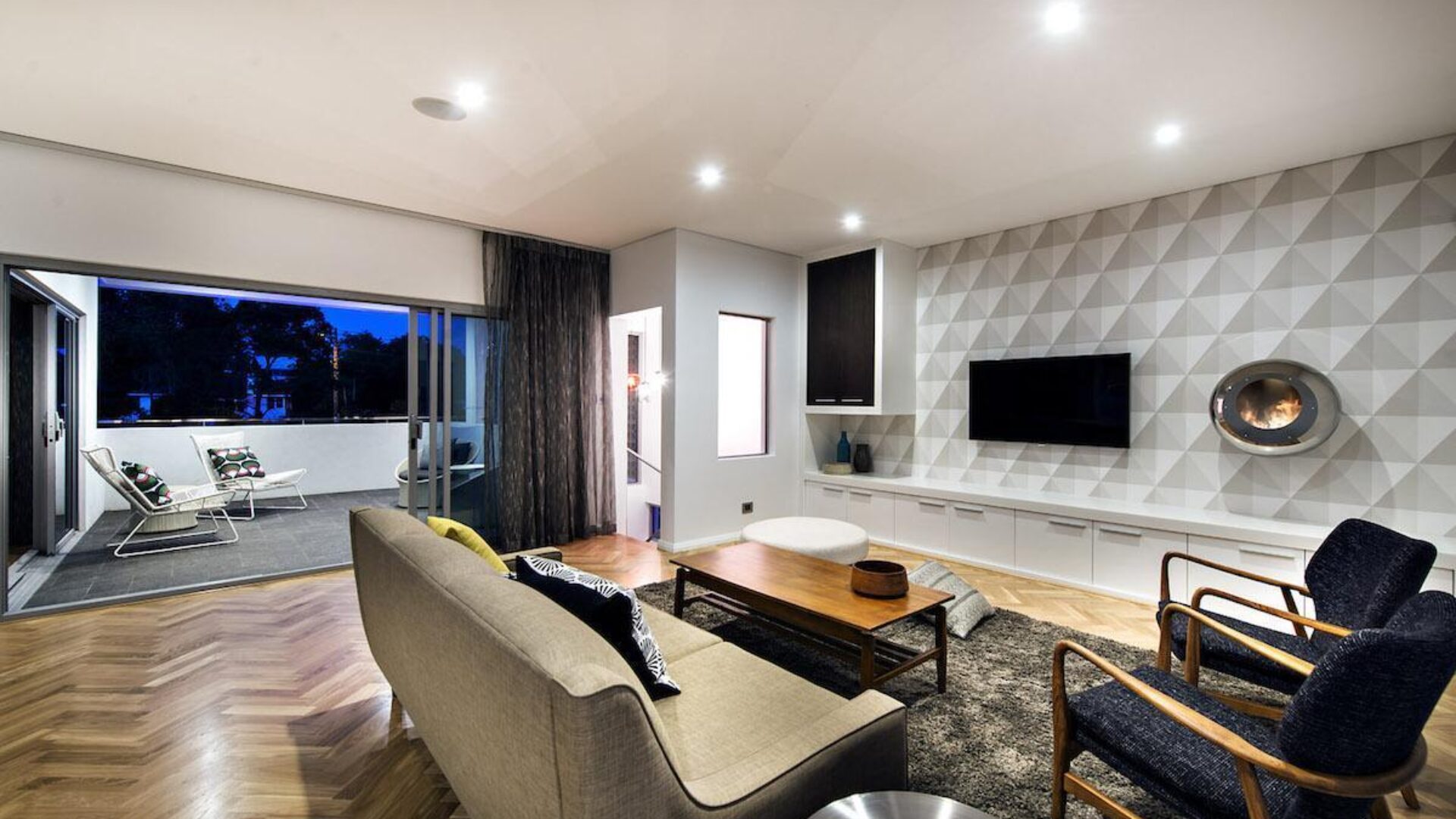 Living room with a feature fireplace wall opening to the alfresco