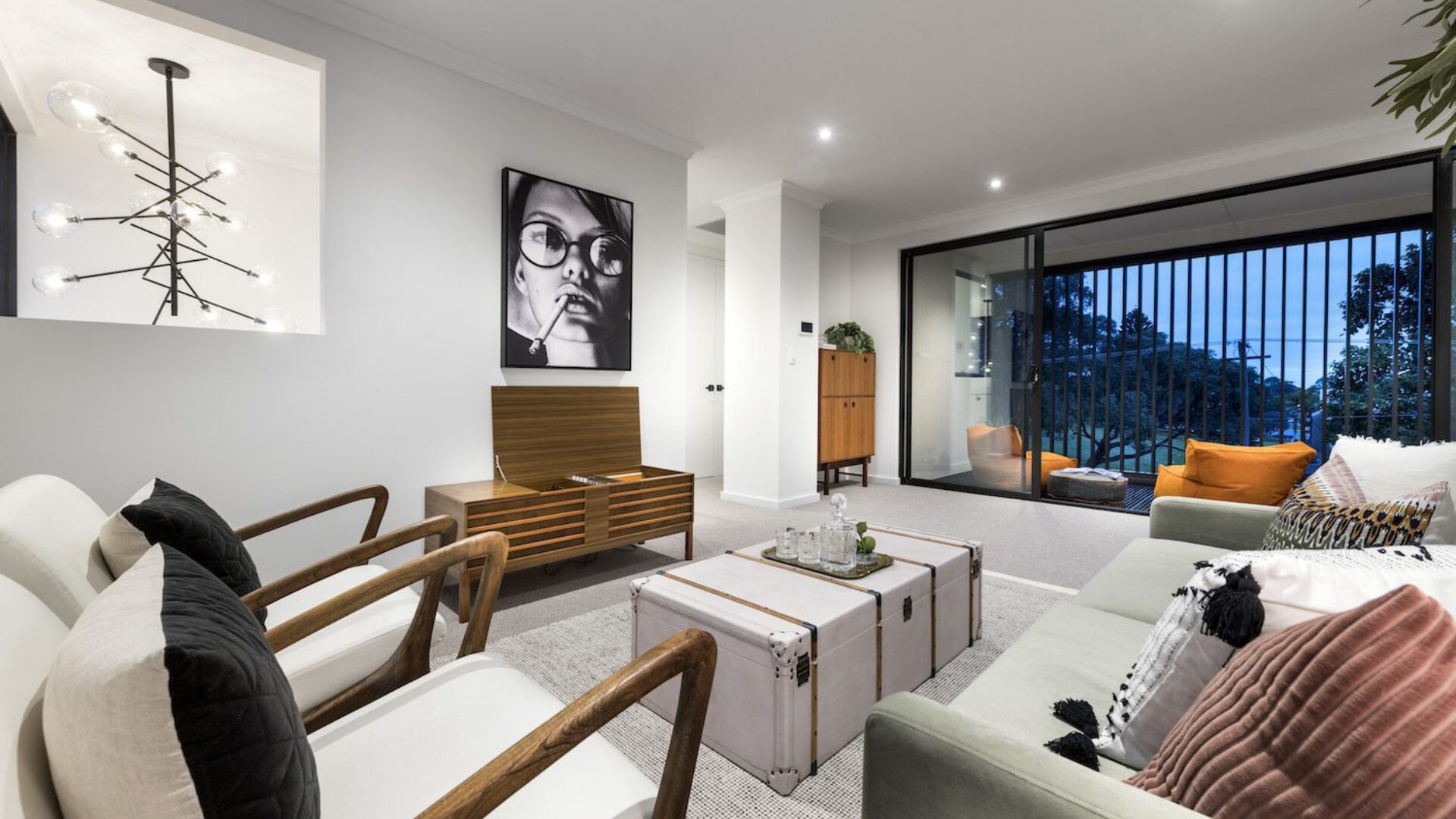 Living room with sculptural pendant light, artwork and cream lounge suite