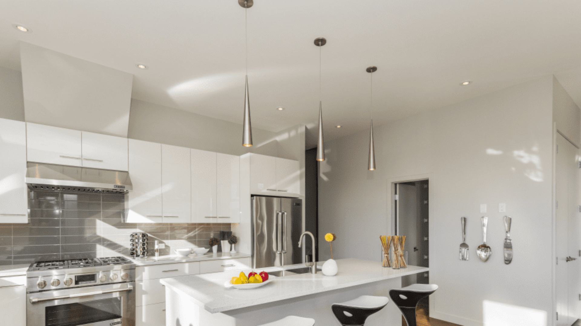 White kitchen with island bench, pendant lighting and stainless steel appliances