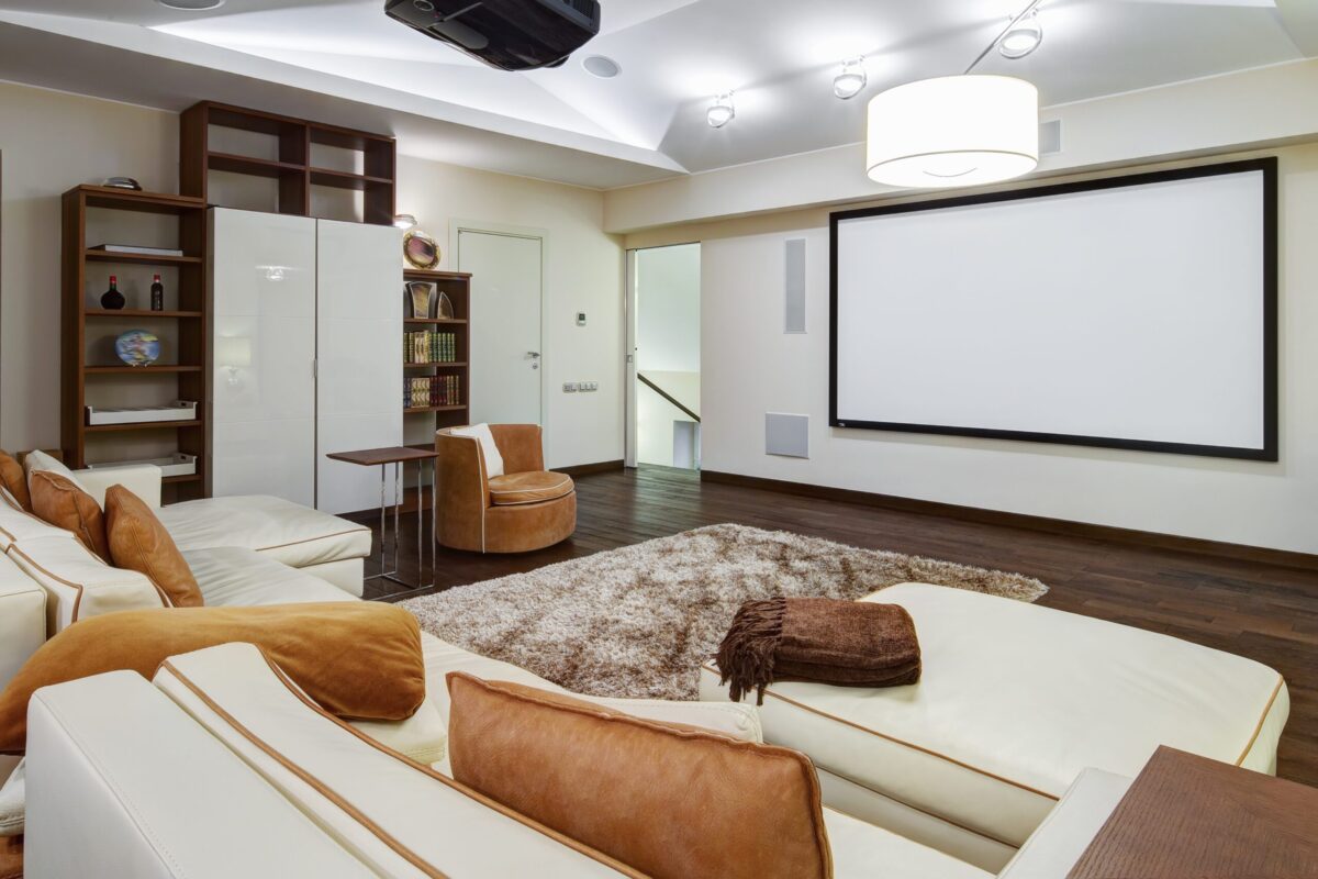 Home theatre with projector screen, cream lounges and timber shelving