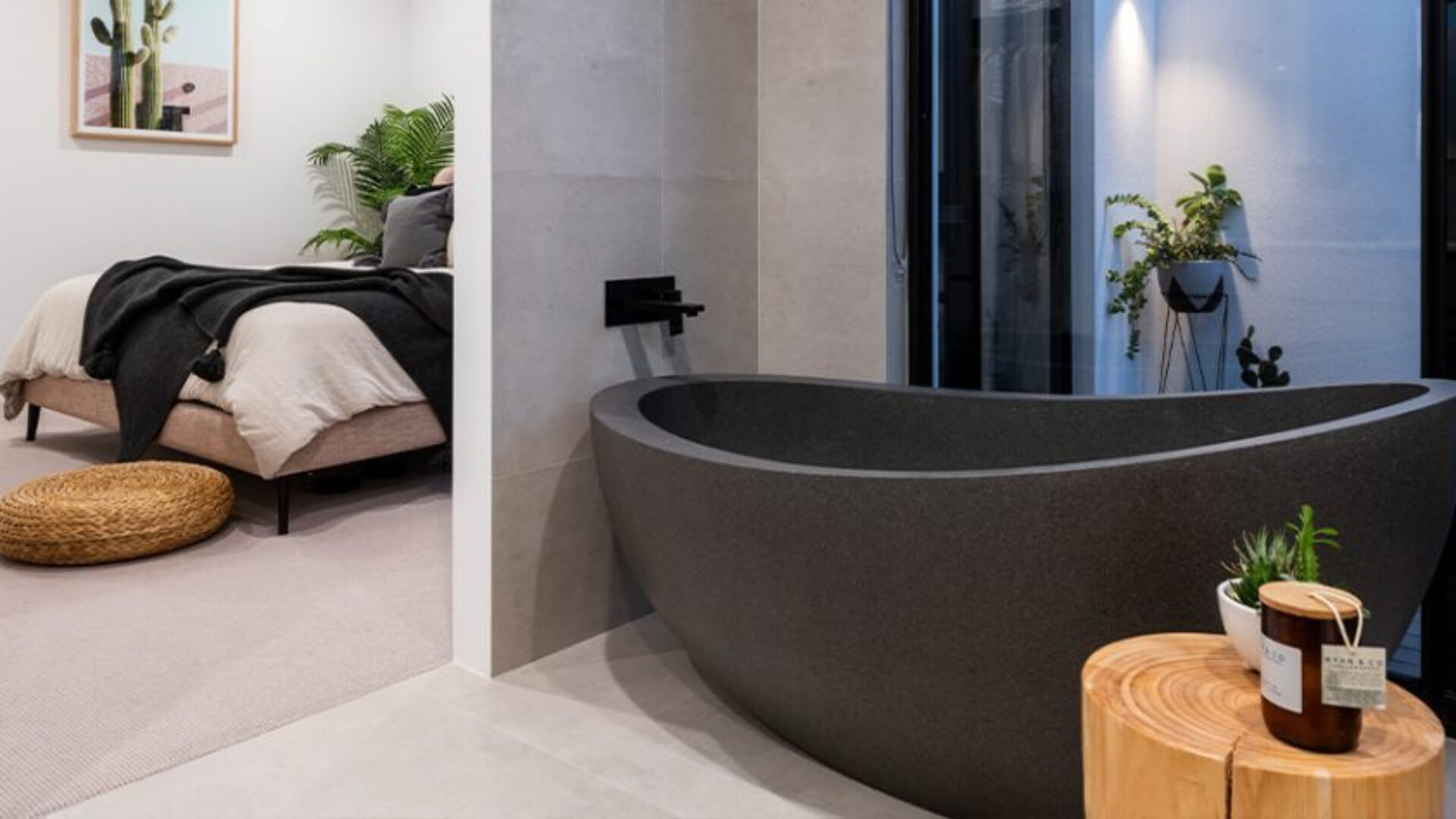 Bedroom with an open ensuite featuring a stone freestanding bath