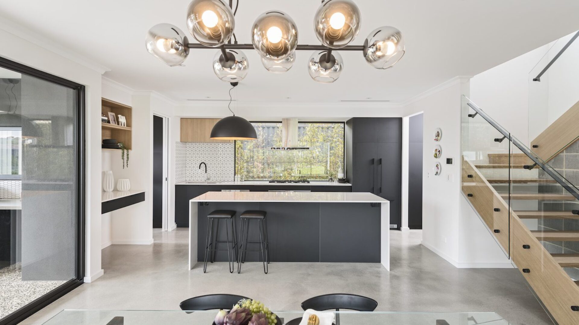 Two storey home kitchen and dining with globe pendant light and staircase