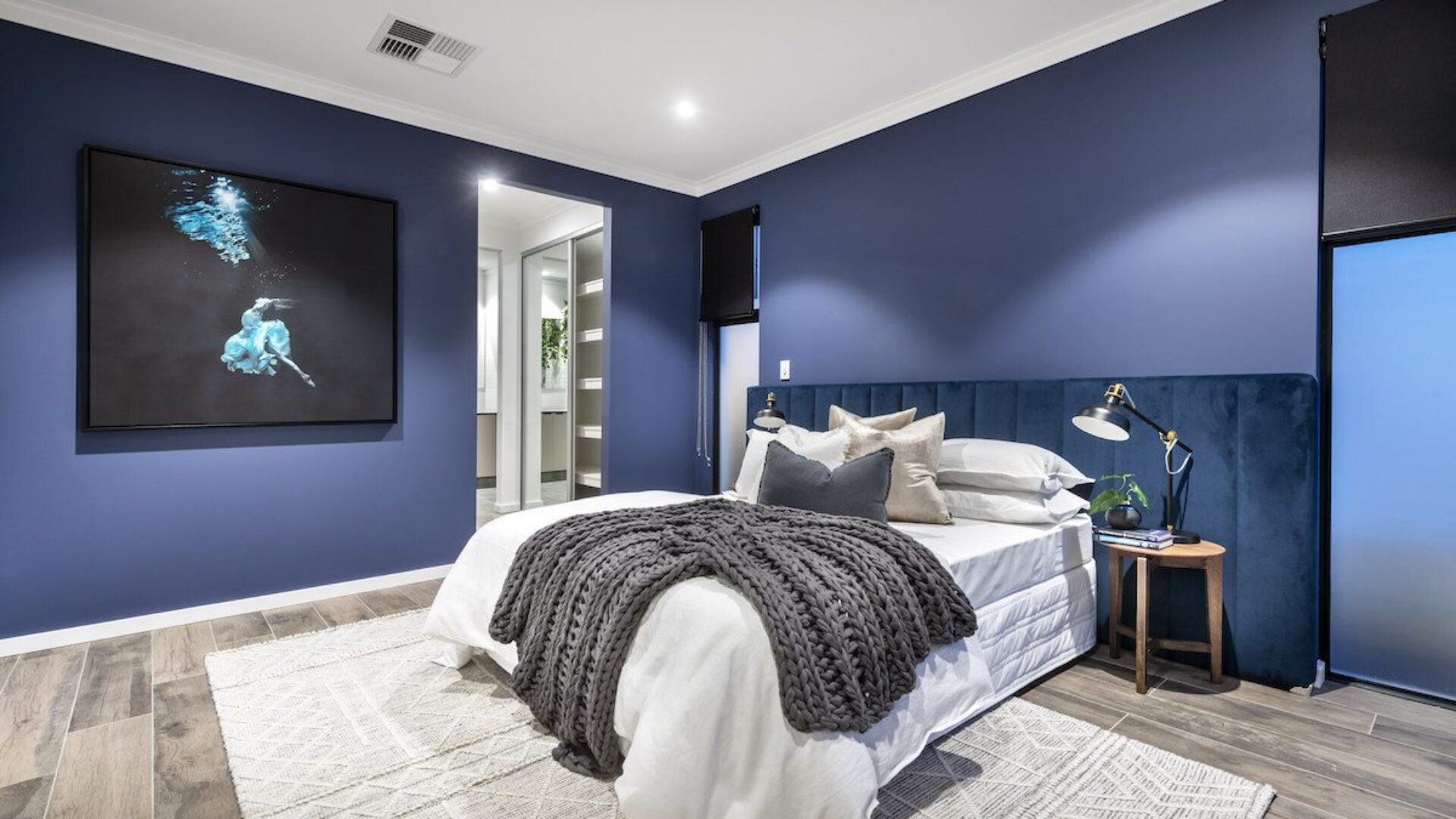 Bedroom with navy feature wall and framed artwork