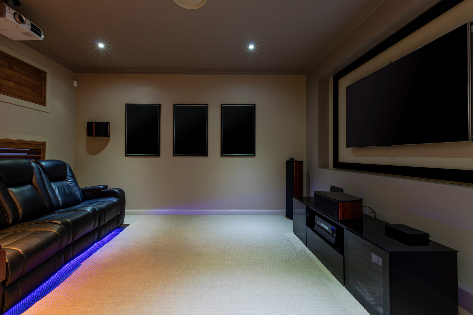 home theatre room with projector and leather lounges