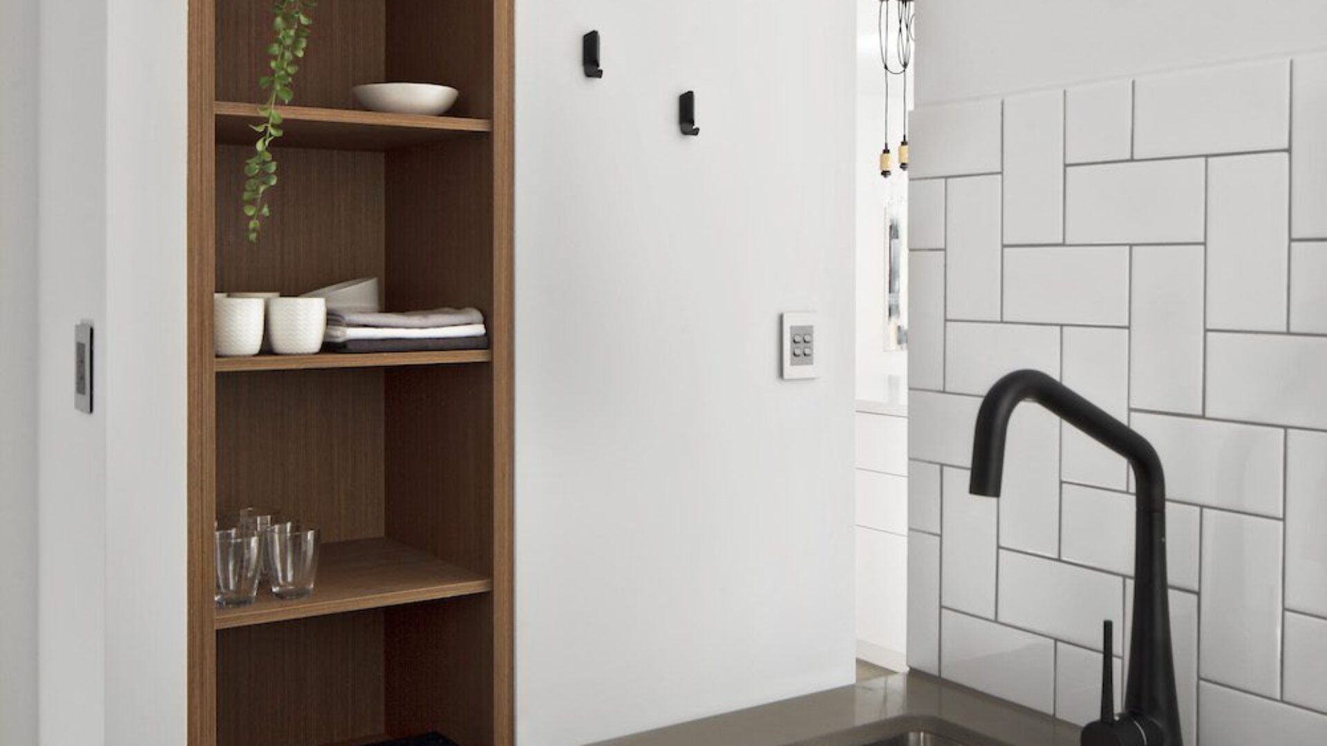 Scullery with stainless steel sink, open shelving and subway tiles