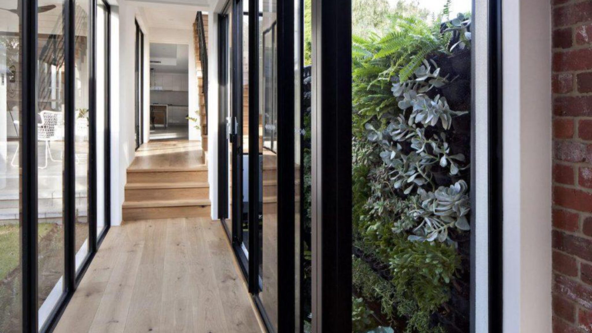 Hallway with a vertical garden wall and timber flooring