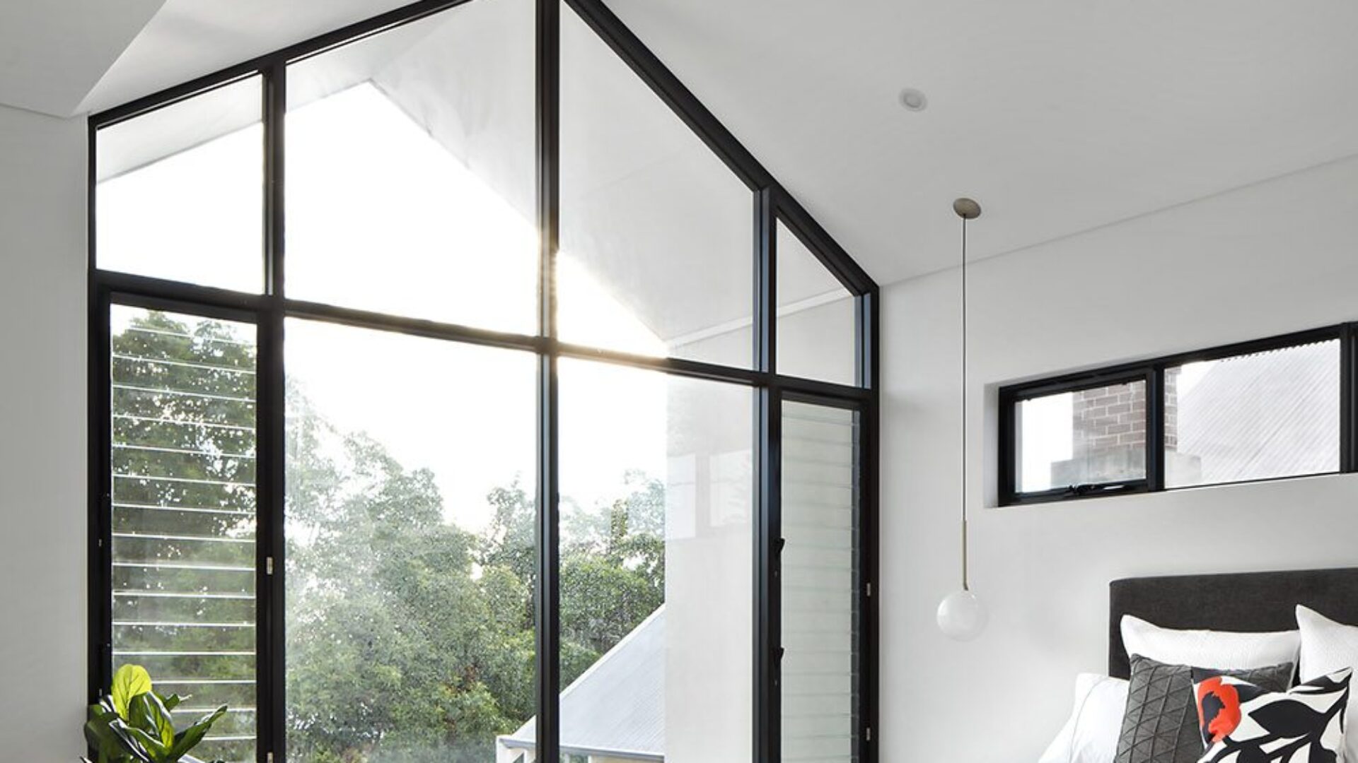 Bedroom with raked ceiling and full height gable window