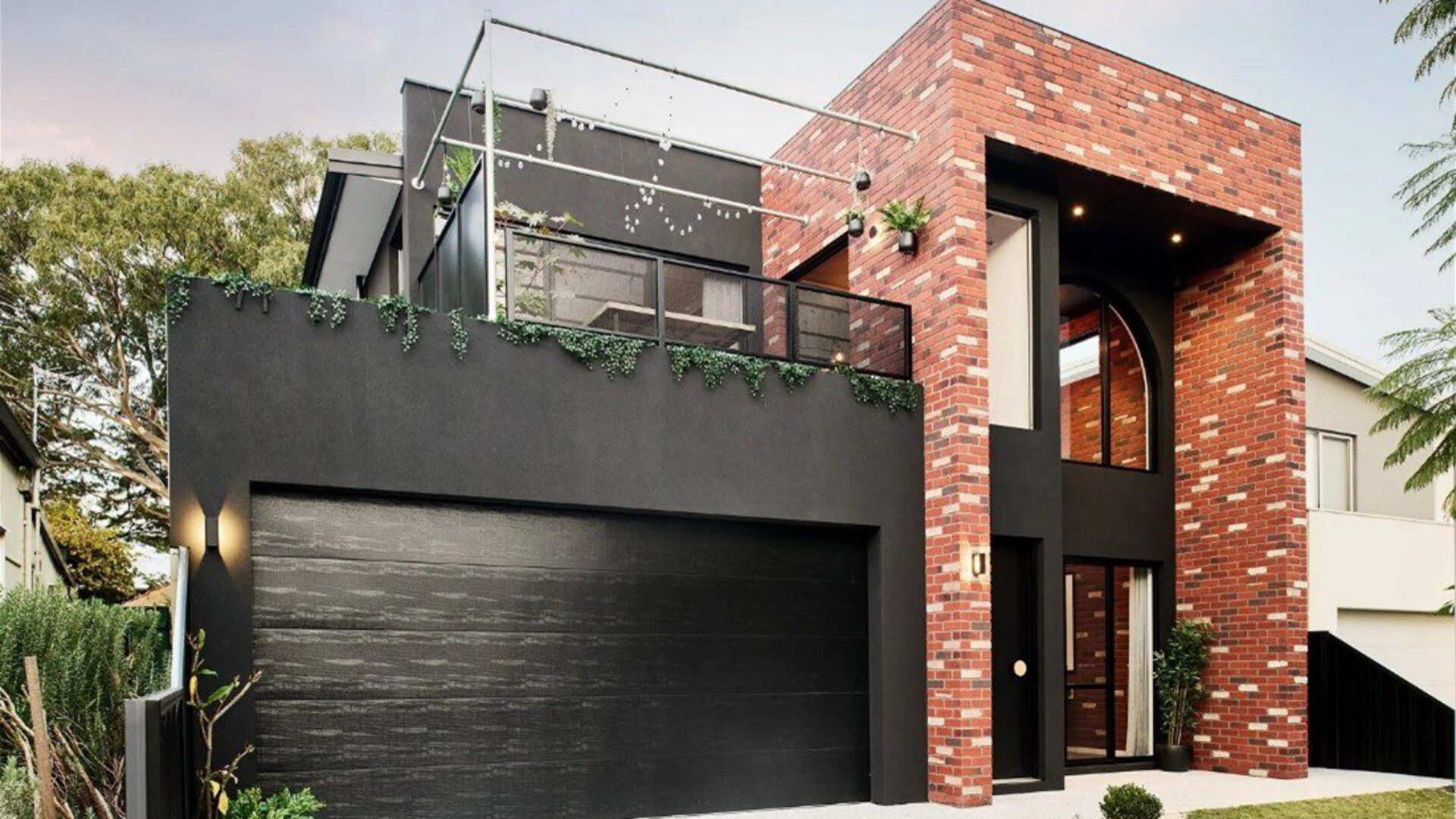 Two storey home with red brick facade and rooftop terrace