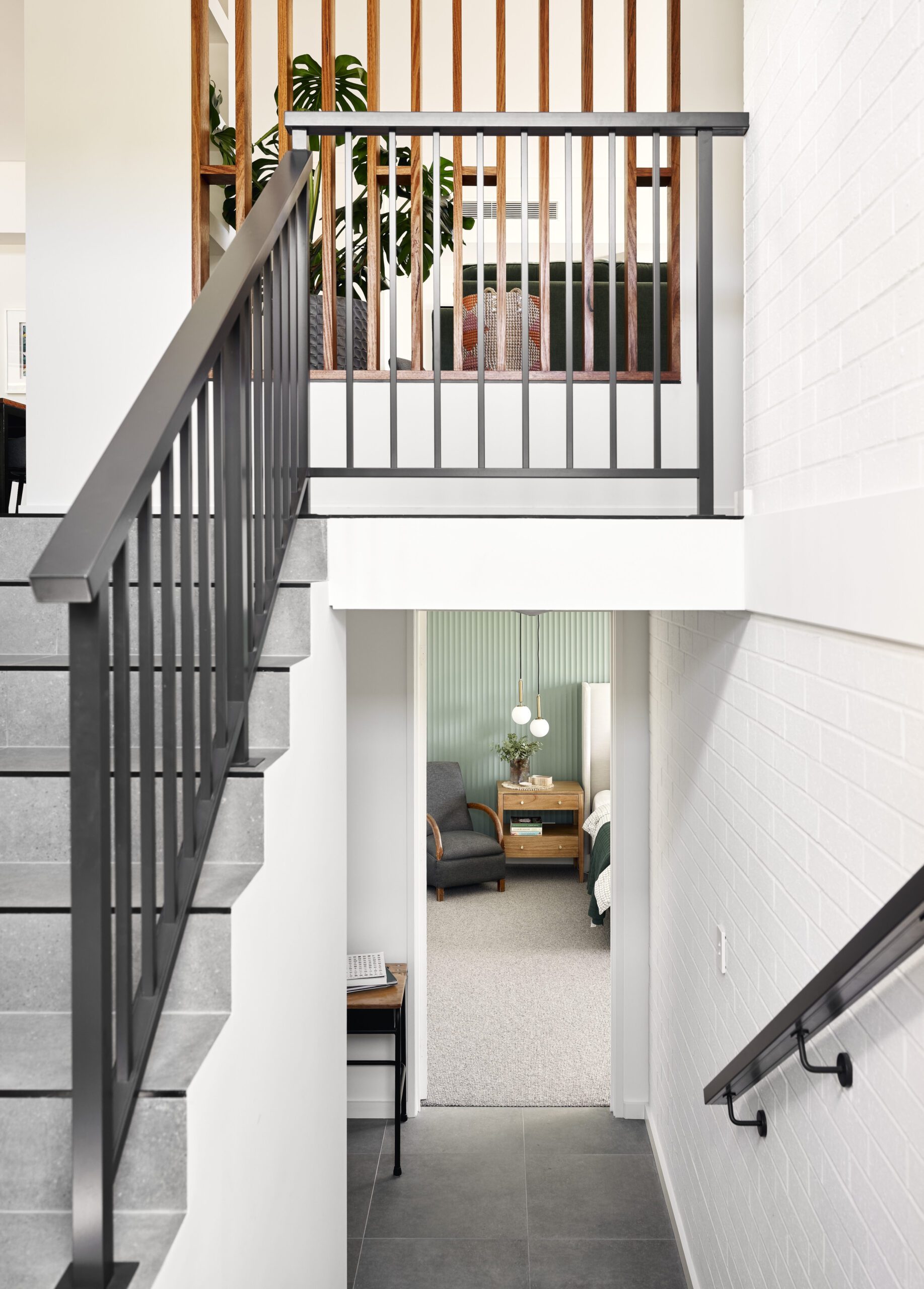 Staircase with black steel balustrade and painted brick wall