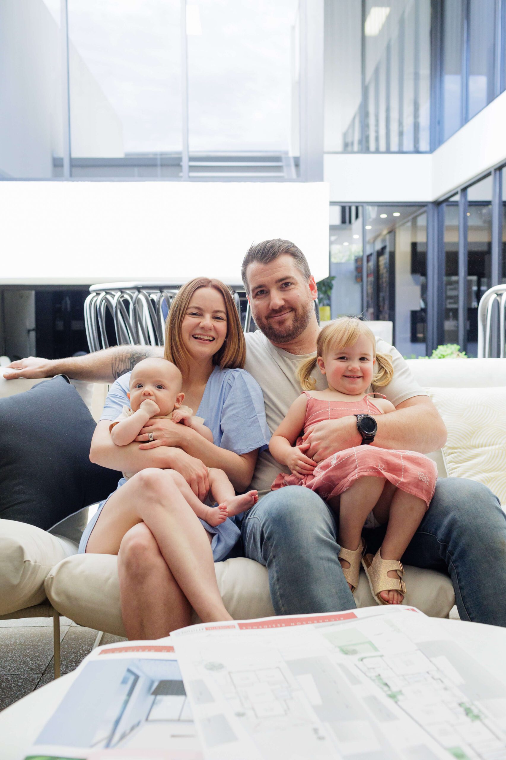 Family with young children reviewing home plans on a sofa