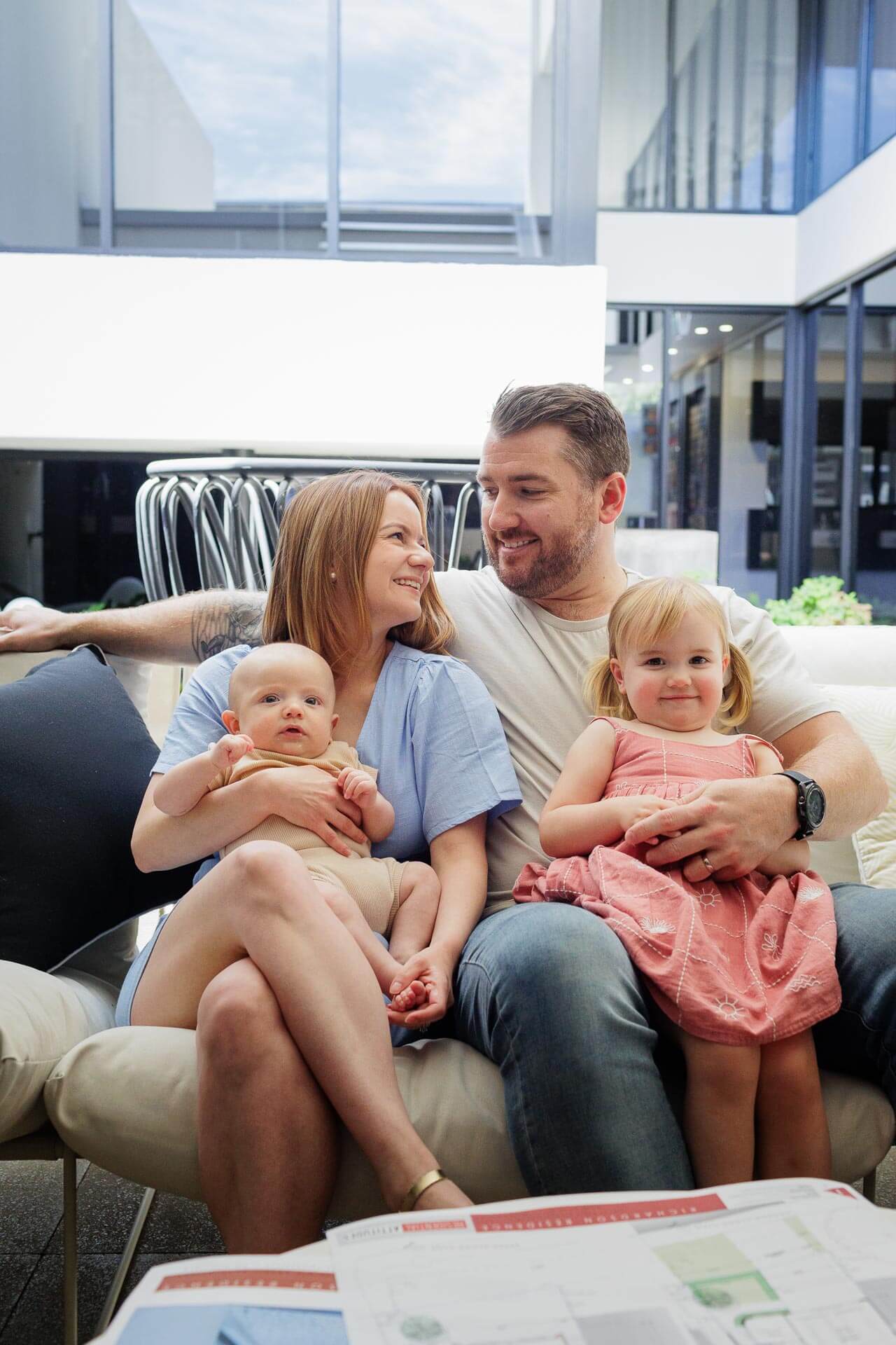 Family with young children on a sofa reviewing home plans