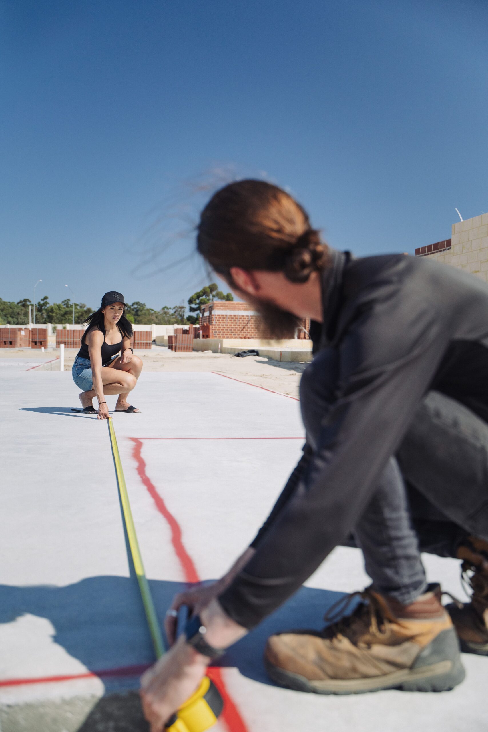 Site supervisor measuring out a new home slab