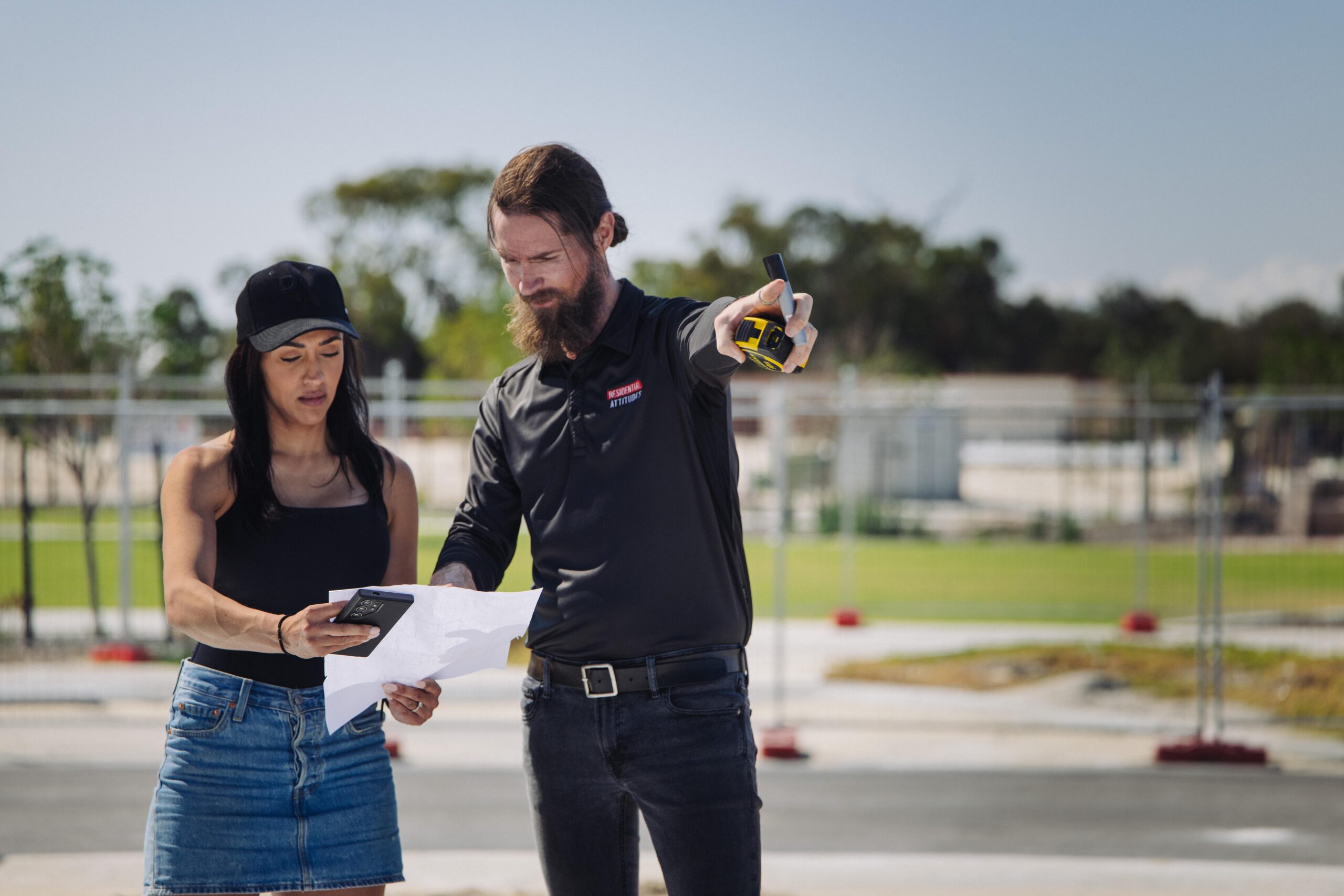 Homeowner and site supervisor reviewing plans at a building site
