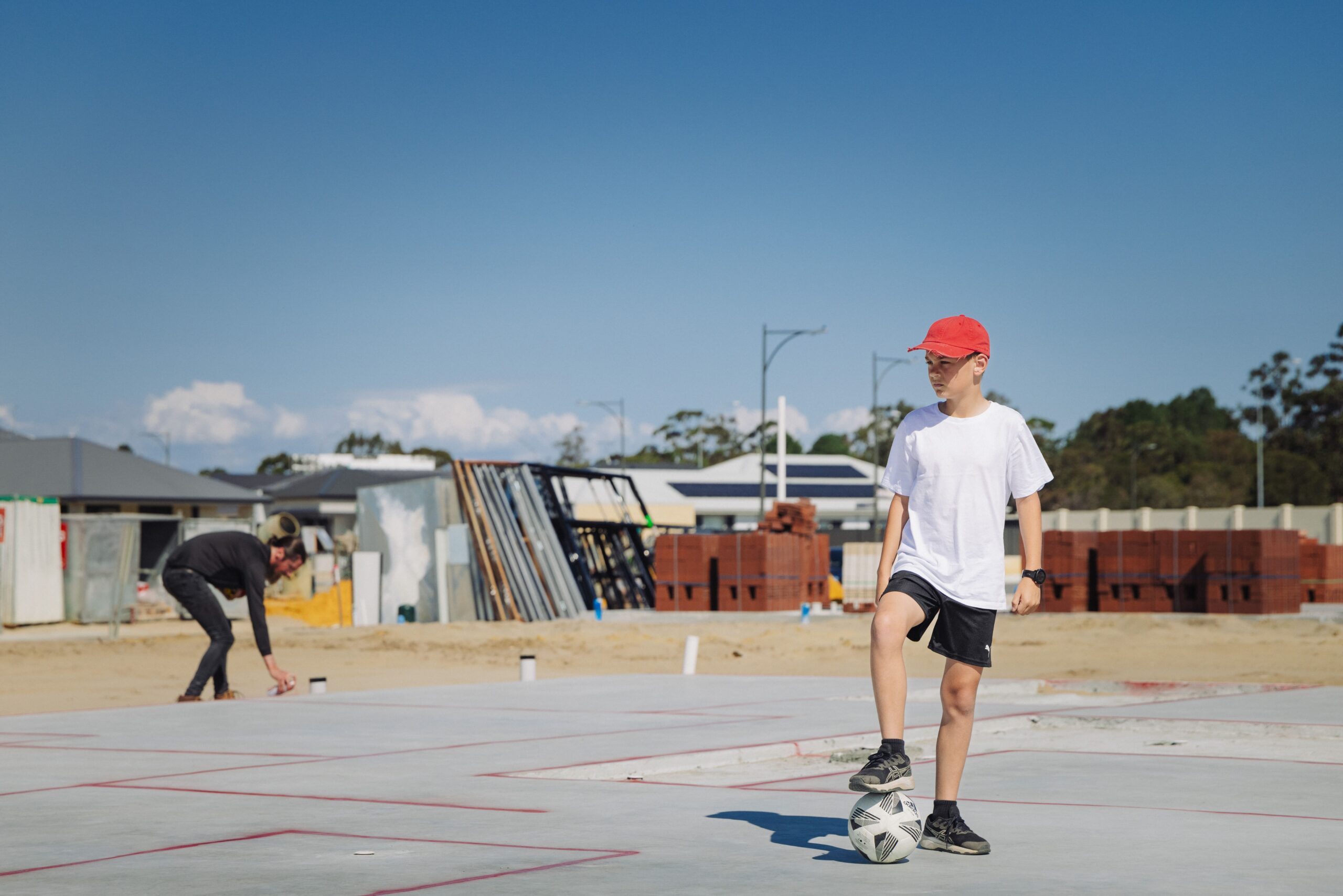 Boy playing with a football on a new home slab