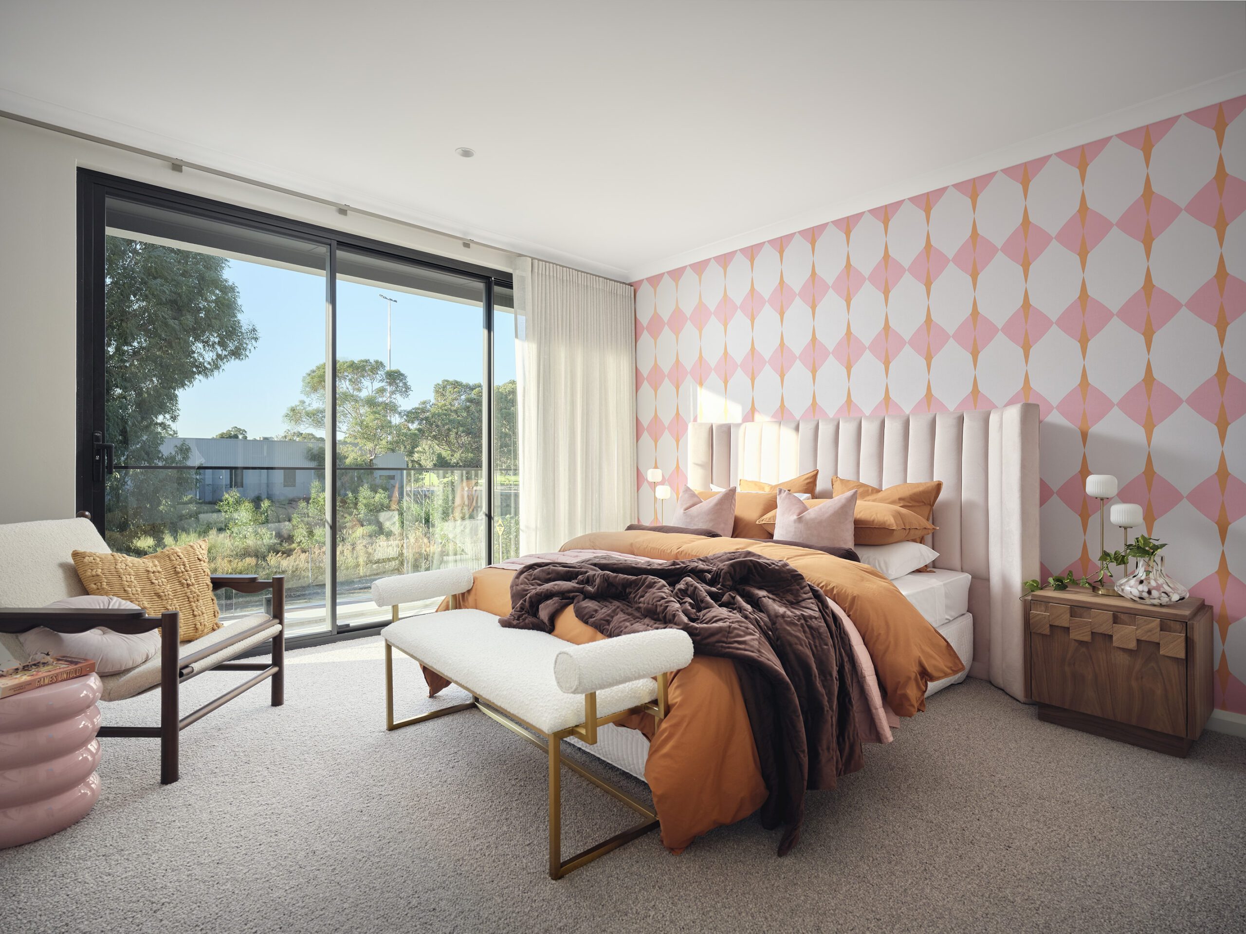 Bedroom with pink geometric feature wallpaper and garden outlook