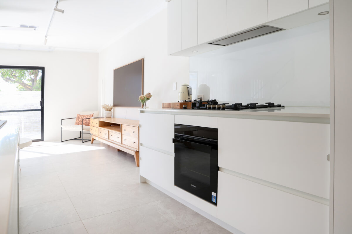 A tidy, hidden rangehood, and dark elements featured in the kitchen of this Contemporary home design. Built by Residential Attitudes.