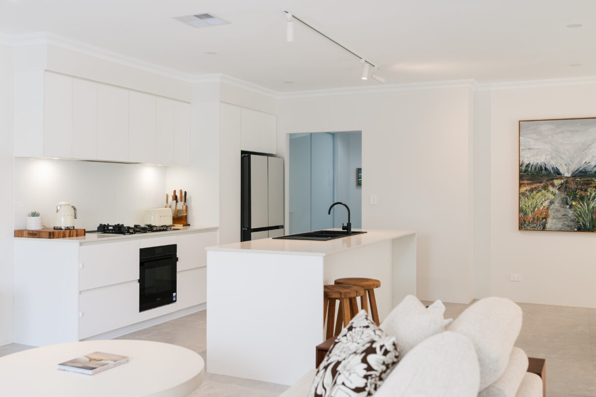 View from the living area looking into a bright, Contemporary-style kitchen. Built by Residential Attitudes.