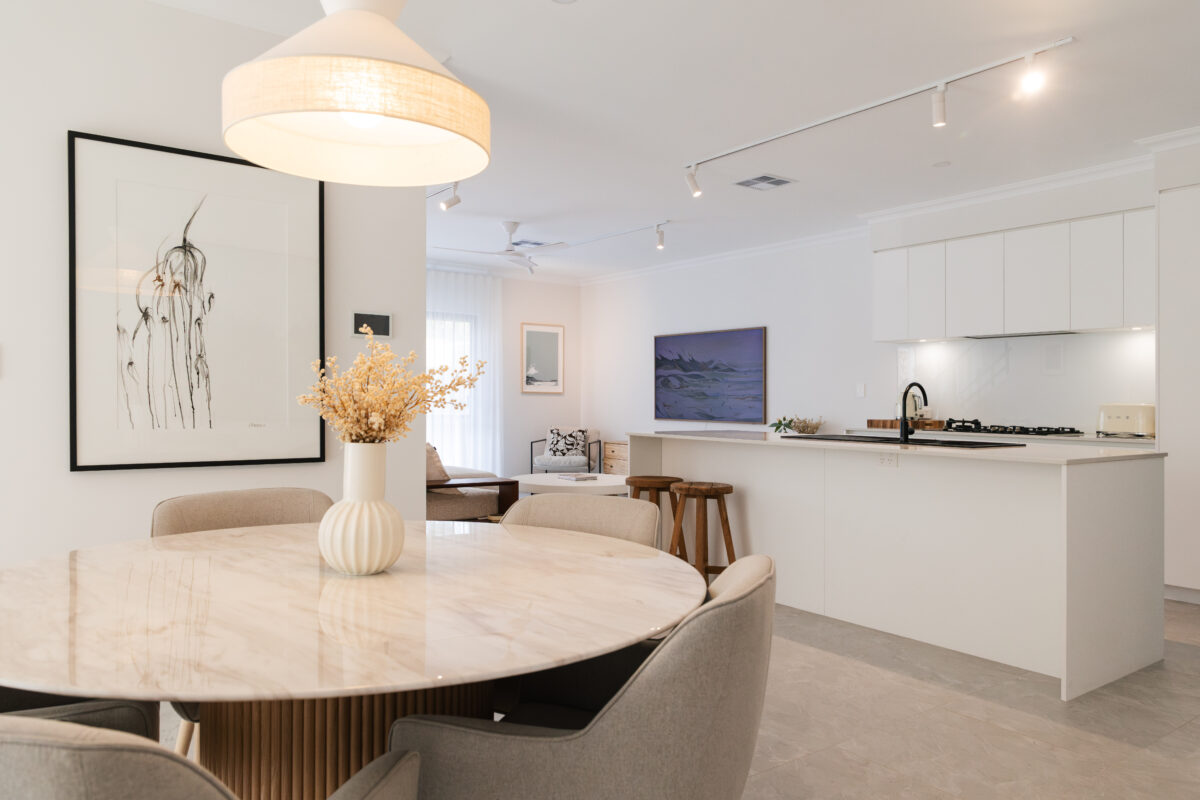 View from the round dining table in the dining room looks into the light-filled kitchen and living area. Built by Residential Attitudes.