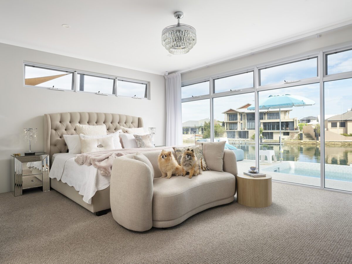 The master bedroom retreat overlooks the picturesque waterfront canal. Sue and Graeme’s Halls Head home was designed for openness and easy coastal living. Built by Residential Attitudes.