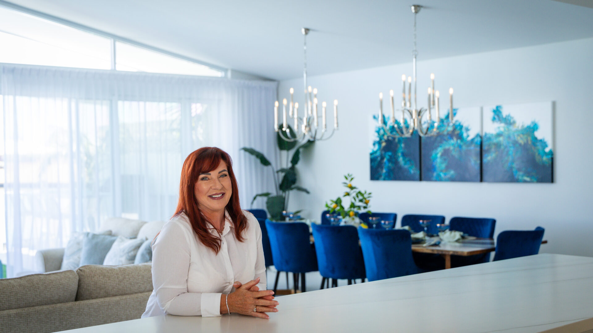 Our lovely client, Sue, sits at the kitchen island benchtop in her new custom home. Built by Residential Attitudes.