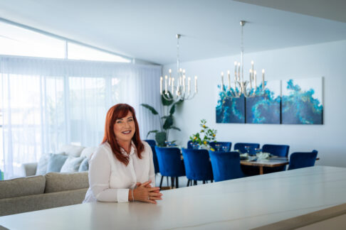 Our lovely client, Sue, sits at the kitchen island benchtop in her new custom home. Built by Residential Attitudes.